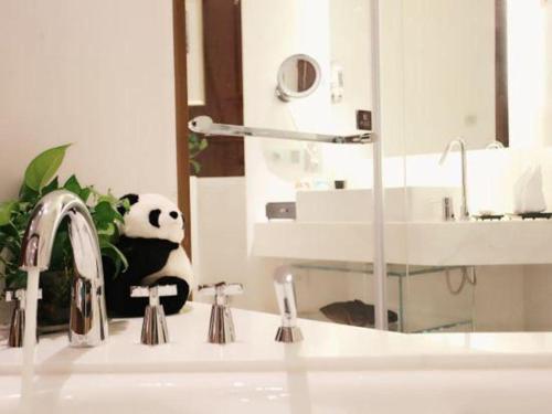 a bathroom sink with a panda bear sitting on the counter at Balan International Hotel in Dujiangyan