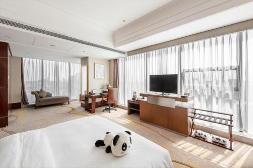 a panda bear sitting on a bed in a hotel room at Balan International Hotel in Dujiangyan