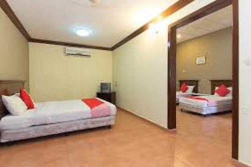 a bedroom with two beds and a large mirror at INB Resort Ayer Keroh in Kampong Ladang Baharu