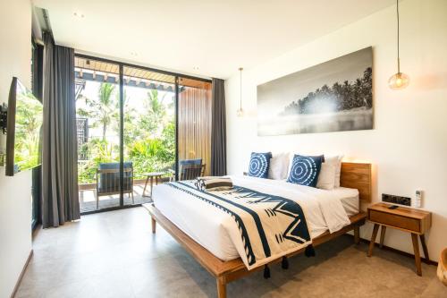 a bedroom with a bed and a large window at New 4BR Villa 200m to the beach Canggu in Canggu