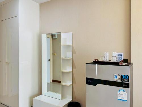 a room with a glass shelf next to a refrigerator at Baan Phing Phu Praew Cha-Am Resort บ้านพิงภูแพรว รีสอร์ท ชะอำ in Cha Am