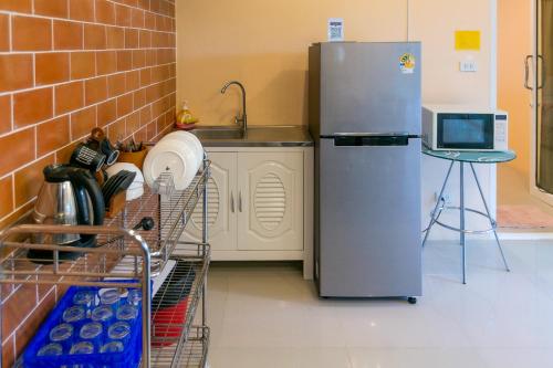 a kitchen with a refrigerator and a sink at Baan Phing Phu Praew Cha-Am Resort บ้านพิงภูแพรว รีสอร์ท ชะอำ in Cha Am