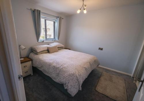 a small bedroom with a bed and a window at Cozy 1 bedroom house close to centre in Hereford