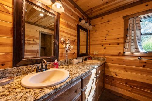 une salle de bain avec deux lavabos dans une cabane en rondins dans l'établissement Pine and Pickle - Cozy Cabin, Sleeps 10, Loft, Hot Tub, Firepit, à Stephens Gap