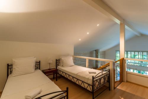 two beds in a room with a balcony at Madame Vacances Villas la Clairière aux Chevreuils in Moliets-et-Maa