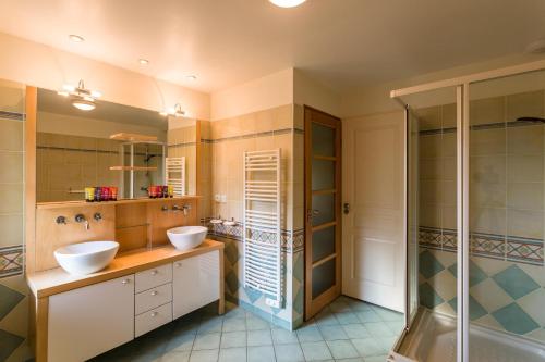 a bathroom with two sinks and a shower at Madame Vacances Villas la Clairière aux Chevreuils in Moliets-et-Maa