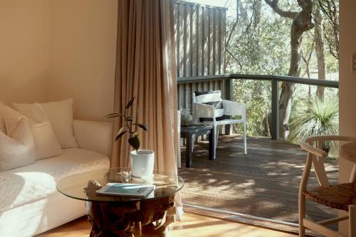 a living room with a couch and a glass table at Empire Spa Retreat in Dunsborough