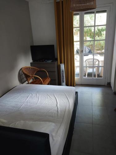 - une chambre avec un lit et une vue sur une terrasse dans l'établissement Studio avec jardin proche plages saint clair Lavandou, au Lavandou