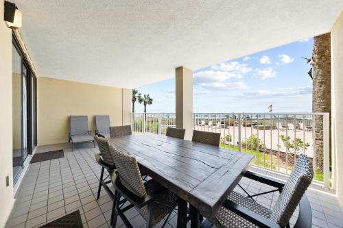 a dining room with a table and chairs on a balcony at White Caps 103 in Orange Beach