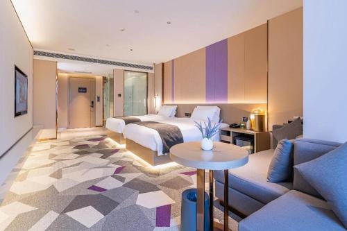 a hotel room with a bed and a couch at Lavande Hotel Tianjin Huayuan in Tianjin