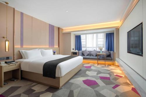 a bedroom with a large bed and a living room at Lavande Hotel Xuchang Pangdonglai Hengdajinhui Plaza in Xuchang