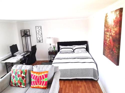 a bedroom with a bed and a desk and a couch at Tilto Executive suite in Saint John