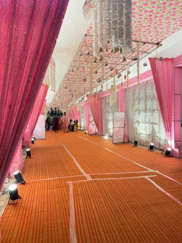 a tennis court with red drapes at Hotel Emperor Paradise in Bilāspur