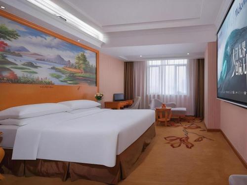 a bedroom with a large white bed in a room at Vienna Hotel Guangdong Shantou South Bus Station in Shantou