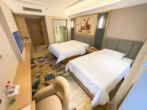 a hotel room with two beds and a chair at Vienna Hotel Chengdu University of Pertroleum Metro Station in Chengdu