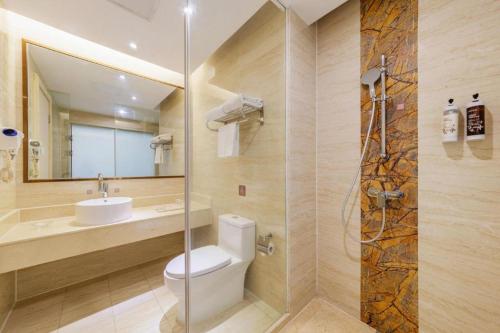 a bathroom with a toilet and a sink and a shower at Vienna Hotel Guangdong Shantou South Bus Station in Shantou