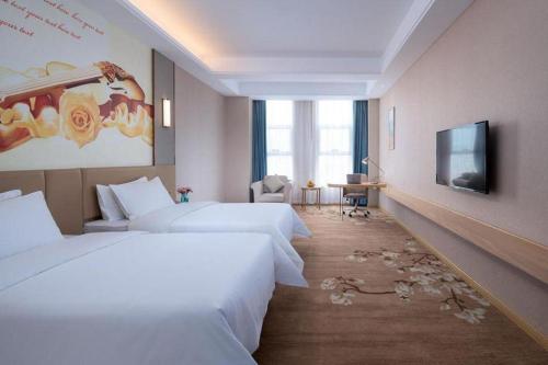 a hotel room with two beds and a flat screen tv at Vienna Hotel Jinan Railway Station in Jinan