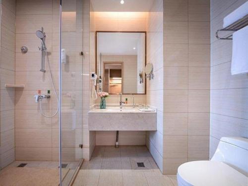 a bathroom with a sink and a shower at Vienna Hotel Jinan Railway Station in Jinan