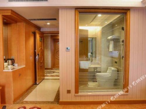 La salle de bains est pourvue d'une porte en verre menant à un lavabo. dans l'établissement Vienna Hotel Henan Luoyang Jiudu Road Wanda, à Luoyang