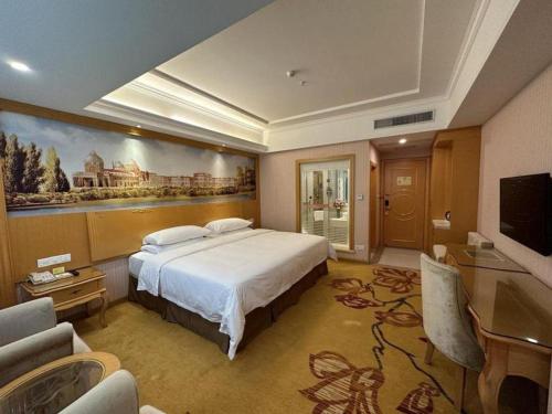 a hotel room with a bed and a television at Vienna Hotel Guangdong Huiyang Qiuchang Yingbin Road in Huizhou