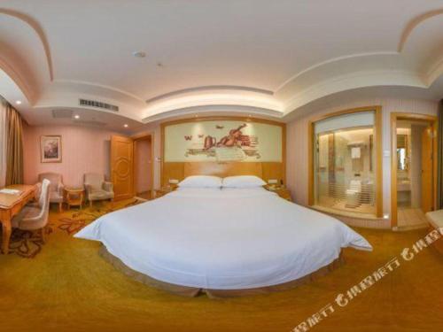 a large bedroom with a large white bed in it at Vienna Hotel Guangdong Huiyang Qiuchang Yingbin Road in Huizhou