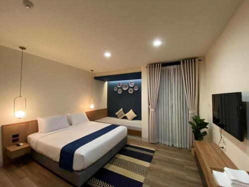 Un dormitorio con una cama grande y un televisor. en Eat Sleep Chann, en Chanthaburi