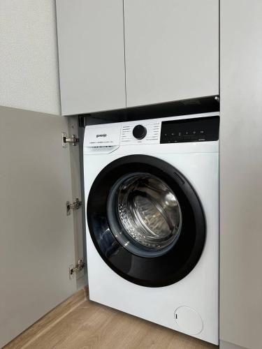 a washing machine is in a white cabinet at Новий комплекс з басейном та видом на Дніпро in Cherkasy