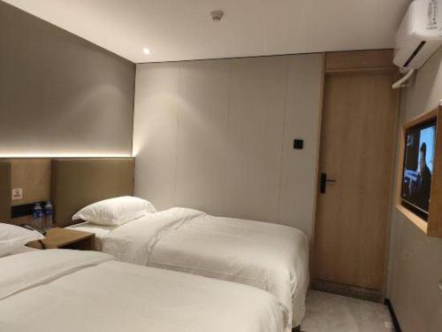 a hotel room with two beds and a tv at Shell Hotel Beijing Shunyi District Shunyi Metro Station in Beijing