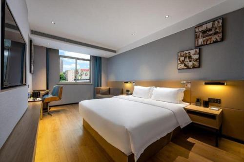 a hotel room with a large bed and a television at VX Hotel Wuhan Optics Valley Yangjia Bay Metro Station in Wuhan