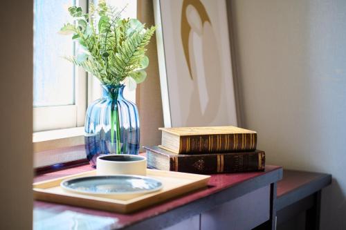 a table with a vase with flowers and books on it at Hotel Sho Sapporo - Vacation STAY 61073v in Sapporo