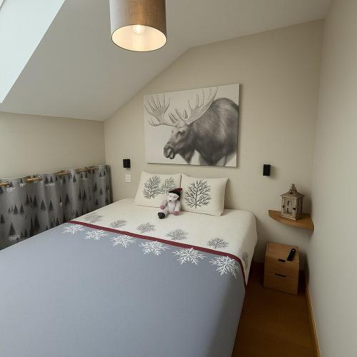 une chambre avec un lit avec un ours en peluche dessus dans l'établissement Nid douillet à la montagne, à Valmorel