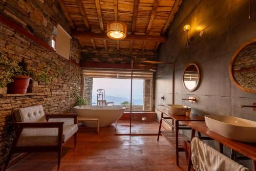 a bathroom with two sinks and a bath tub at Kot Kailash Kumaon in Almora