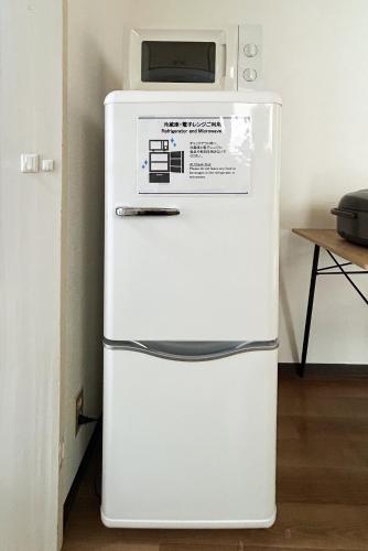 a white refrigerator with a microwave on top of it at 駅から徒歩5分池袋まで電車で5分の好立地 in Tokyo