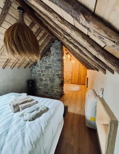 a bedroom with a bed and a stone wall at Au ptit Gaston in Durbuy