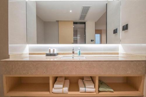 a bathroom with a sink and a large mirror at City Comfort Inn Hengyang East Station Linghu Wanda Industry College in Xiantang