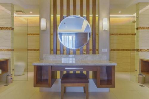 a bathroom with a sink with a mirror and a stool at Mansion Garden Hotel in Olongapo