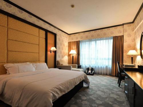 a hotel room with a large bed and a desk at New Pearl River Hotel in Guangzhou