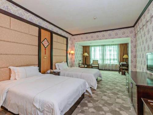 a hotel room with two beds and a television at New Pearl River Hotel in Guangzhou