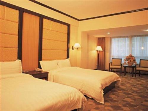 a hotel room with two beds and a table at New Pearl River Hotel in Guangzhou