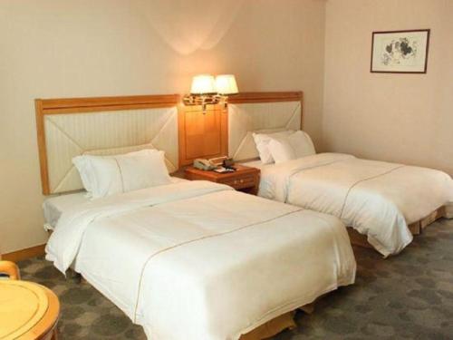 a hotel room with two beds and a table at New Pearl River Hotel in Guangzhou