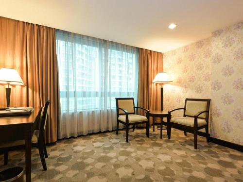 a hotel room with a table and chairs and a window at New Pearl River Hotel in Guangzhou
