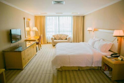 a hotel room with a large bed and a television at New Pearl River Hotel in Guangzhou