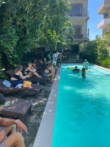 a group of people sitting around a swimming pool at Surf Gangs Arugambay in Arugam Bay
