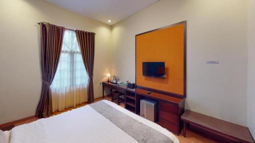 a bedroom with a bed and a mirror and a tv at Ole Suite Hotel in Bogor