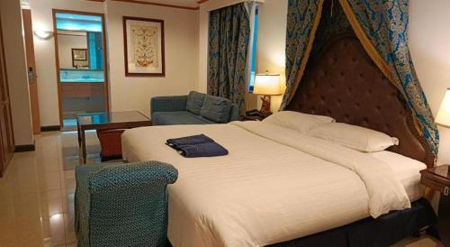 a hotel room with a large bed and a chair at Subic Bay Venezia in Olongapo