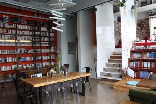 a dining room with a table and some books at Andong Poong-gyung HOSTEL n LIBRARY in Andong