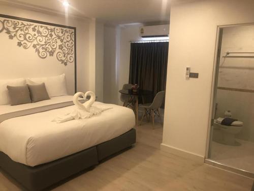 a bedroom with a bed with two swans on it at white house in Phangnga