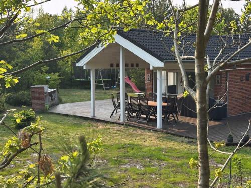 a house with a deck with a table and chairs at Cozy Newer Large Holiday Home In Snogebæk in Neksø