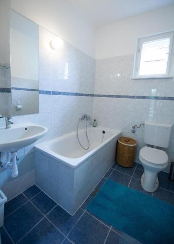 a bathroom with a tub and a sink and a toilet at Orgona Vendégház in Alsóörs