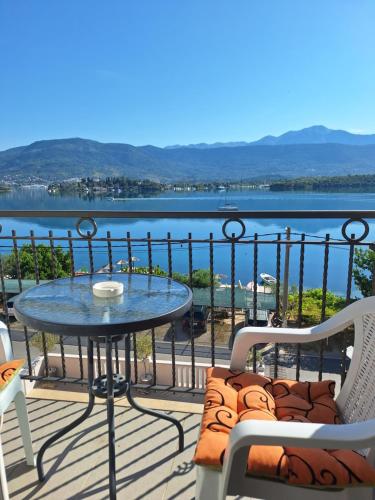a table and chairs on a balcony with a view of the water at Apartments Klakor PS in Tivat
